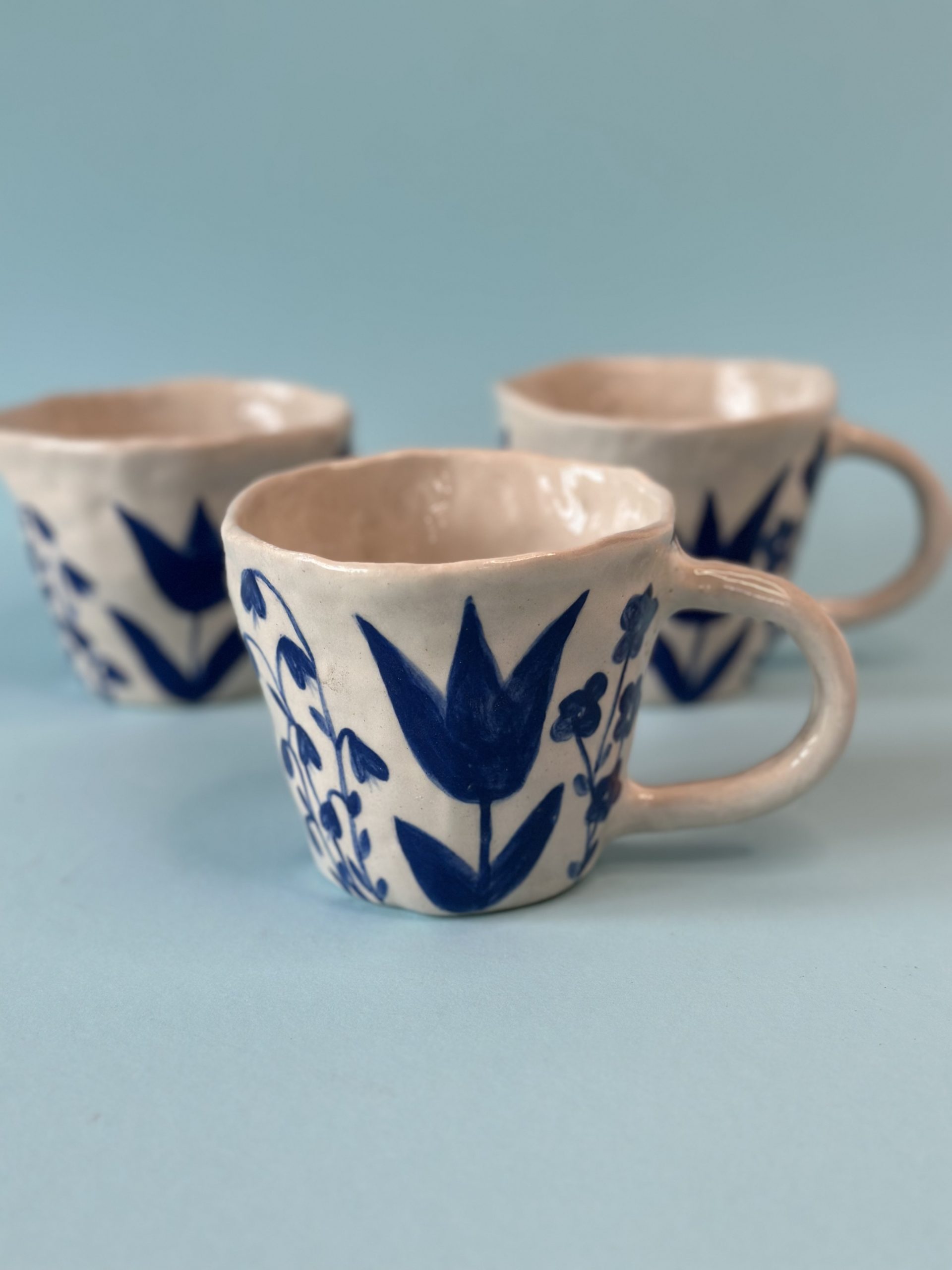 Keramikbecher mit blauem Blumenmuster